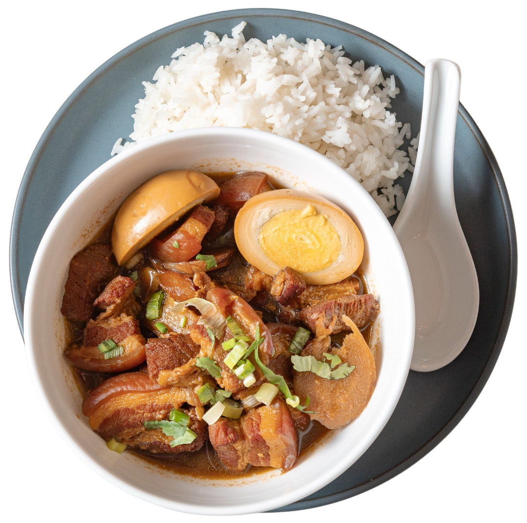 This is a sweet and savory caramelized braised pork belly stew served in a bowl with jasmine rice.