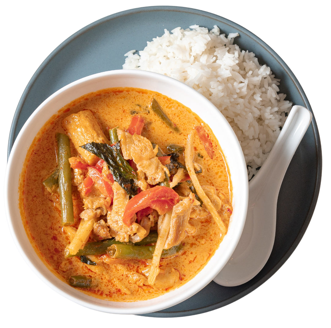 This is a spicy Chicken Red Curry Soup served with jasmine rice in a bowl.