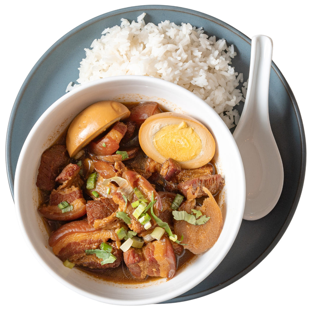 This is a sweet and savory caramelized braised pork belly stew served in a bowl with jasmine rice. 